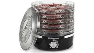 The image shows a compact, multi-tiered food dehydrator with food inside, ideal for small kitchens.