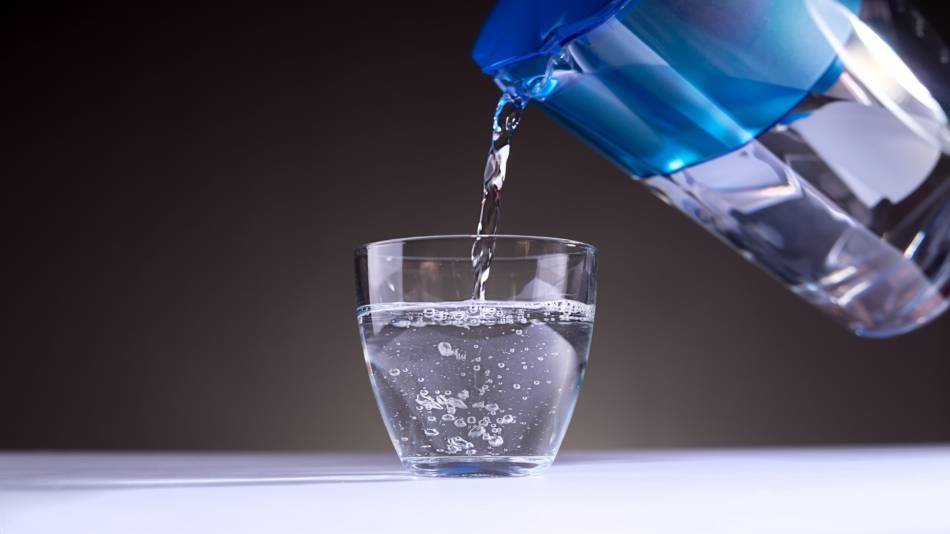 An under-sink reverse osmosis water filtration system is being carefully installed for clean water.