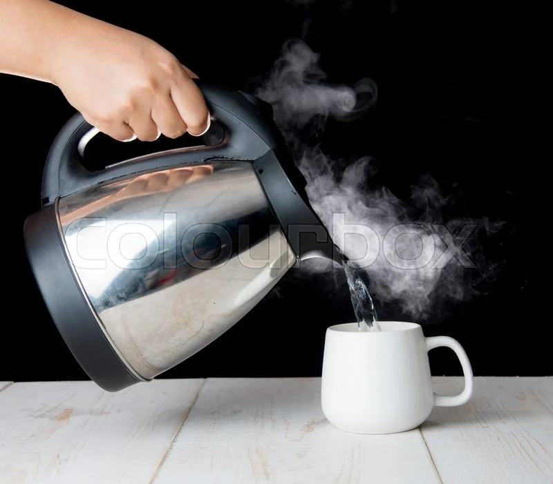 electric kettle pouring boiling water into tea cup