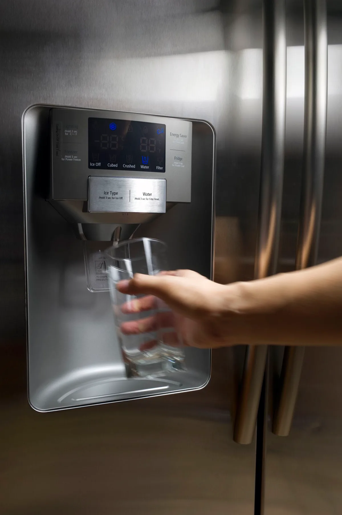 fridge water dispenser running water into glass